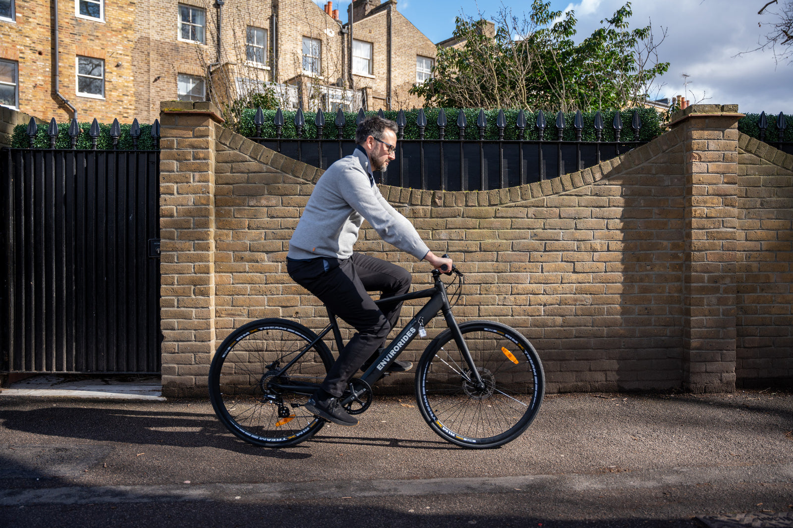 A man riding an eBike on the pavement without a helmet