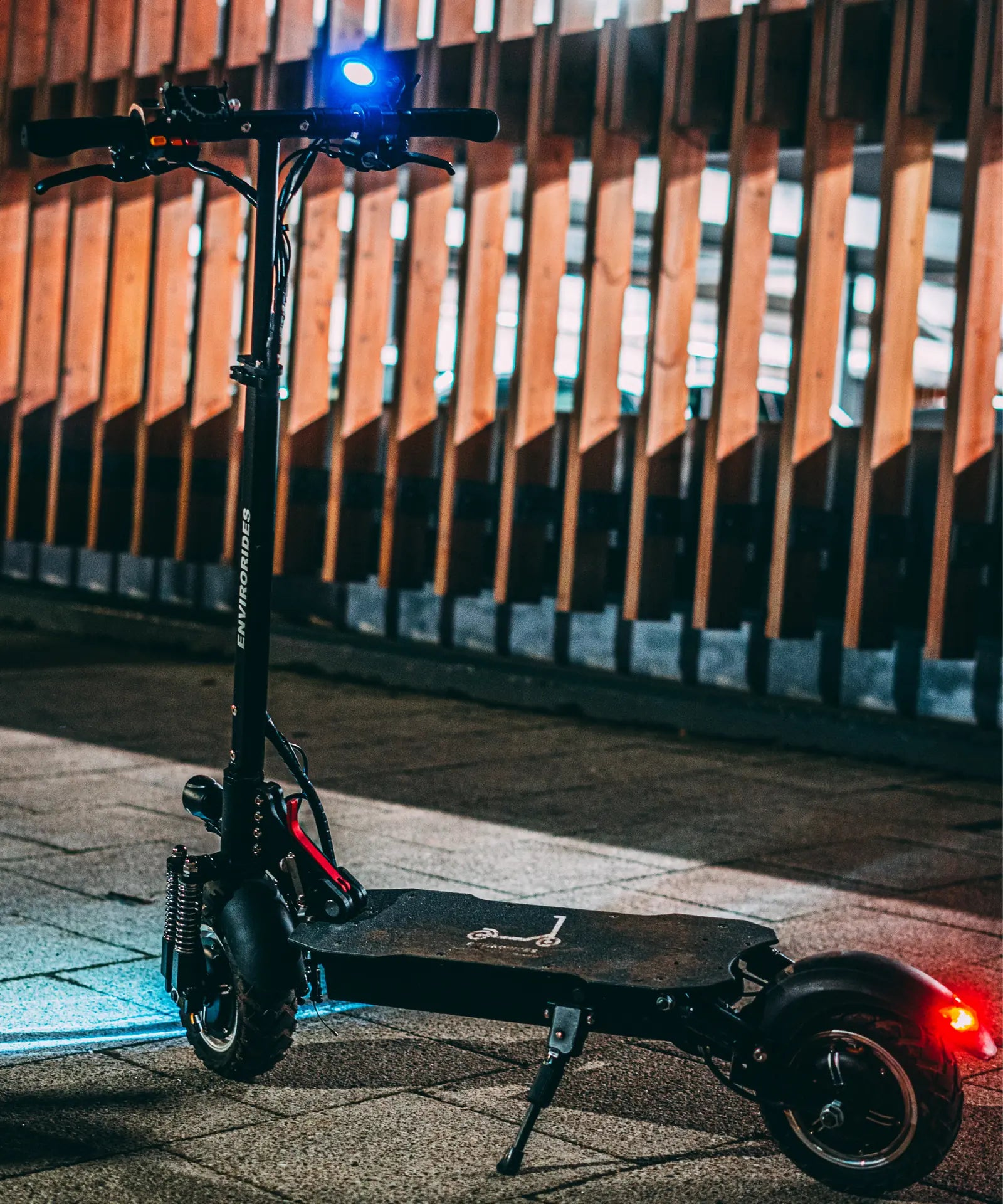 Electric scooter parked at night with front and rear lights illuminated